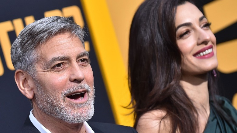 George Clooney parle et Amal Clooney sourit 
