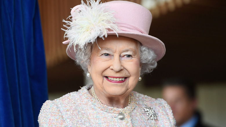 La reine Elizabeth II souriante en rose clair