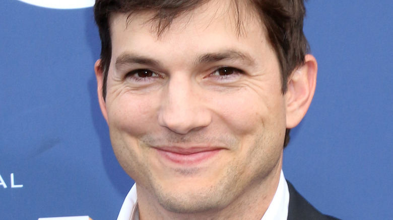 Ashton Kutcher sourit pour les caméras lors de l'événement