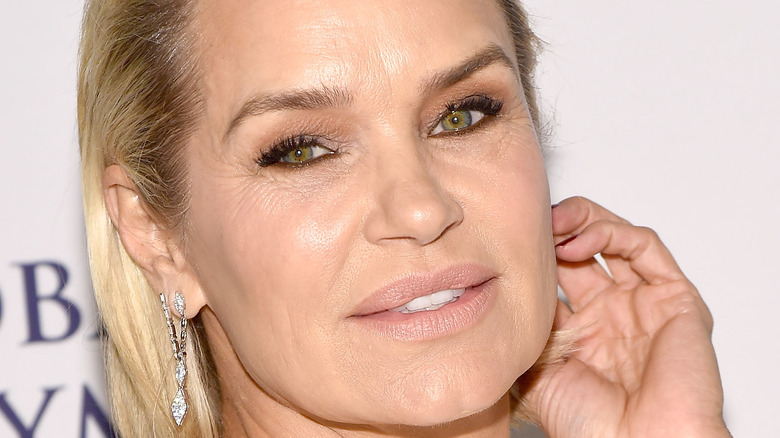 Yolanda Hadid tenant la main à l'oreille de longues boucles d'oreilles en diamant