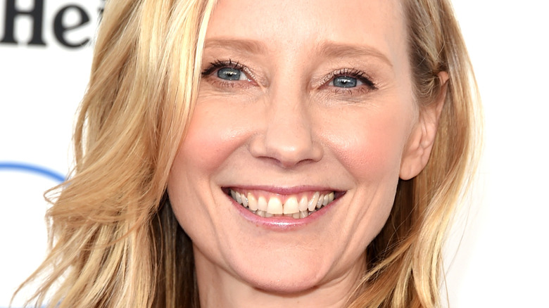 Anne Heche sourit sur fond blanc