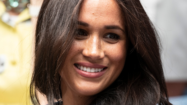 Meghan Markle souriante regardant de côté