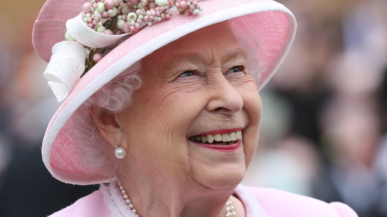 La reine Elizabeth II en chapeau rose