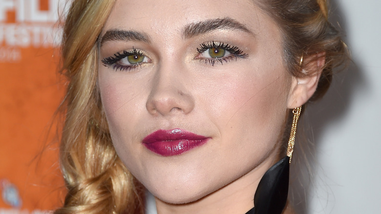 Florence Pugh avec une grande boucle d'oreille noire, posant