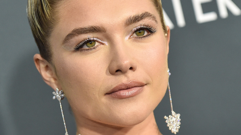 Florence Pugh avec de grandes boucles d'oreilles, posant