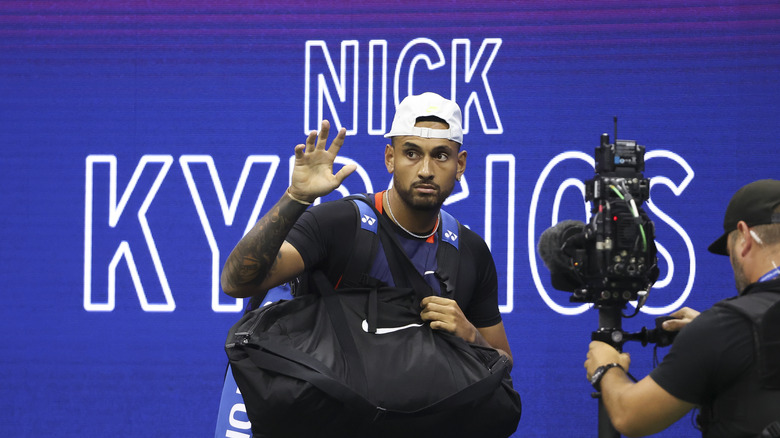 Nick Kyrgios fait signe sur un court de tennis