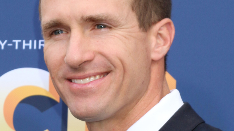 Drew Brees en costume et souriant