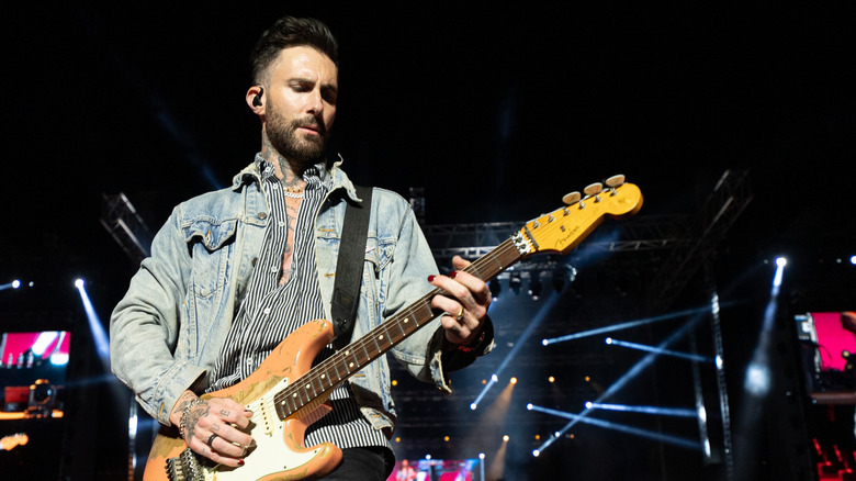 Adam Levine joue de la guitare sur scène