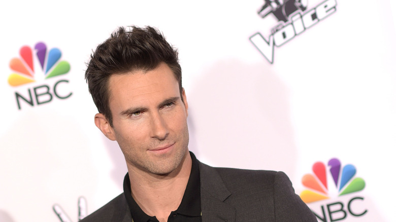 Adam Levine posant lors d'un événement