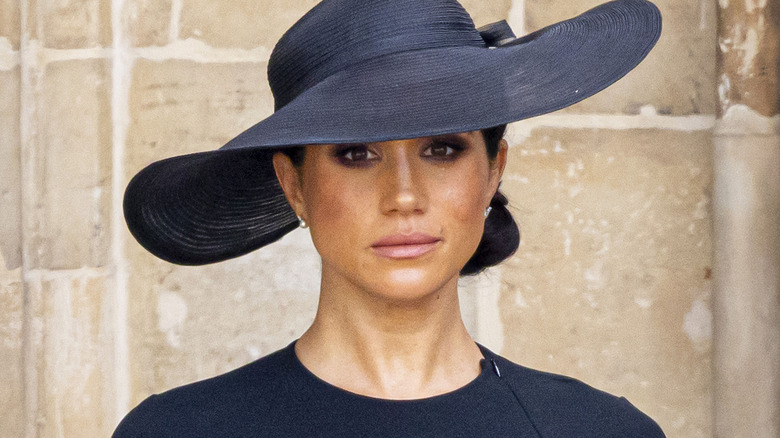 Meghan Markle portant un chapeau noir