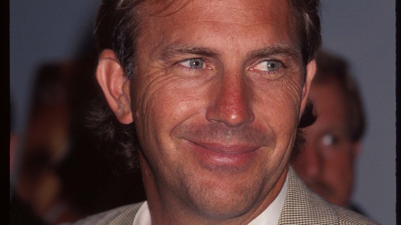 Kevin Costner sourit dans un costume beige