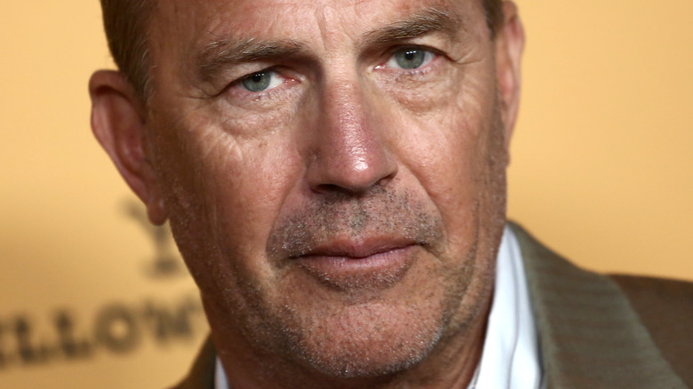 Kevin Costner grimace devant un fond orange