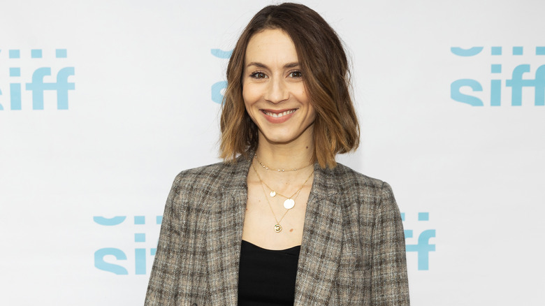 Troian Bellisario souriant sur le tapis rouge