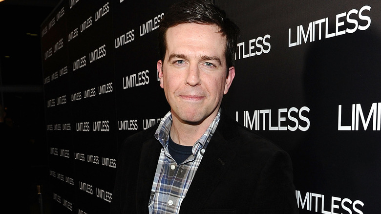 Ed Helms souriant, chemise à carreaux