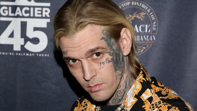 Aaron Carter montrant son tatouage sur le visage