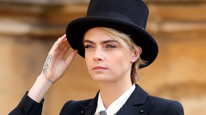 Cara Delevingne portant un chapeau, posant