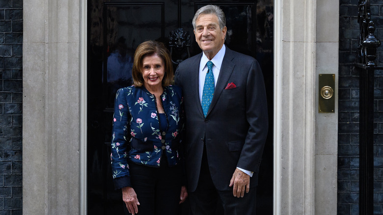 Nancy et Paul Pelosi souriant devant une porte