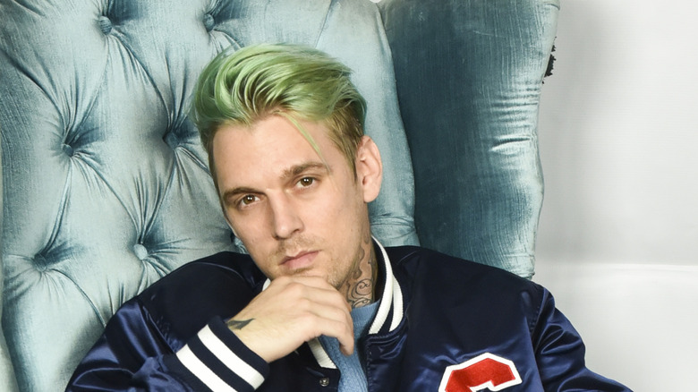 Aaron Carter assis sur une chaise