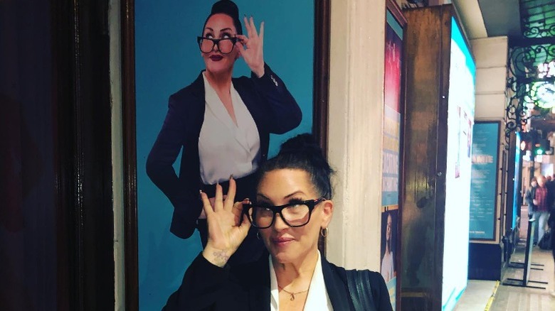 Michelle Visage posant devant une affiche