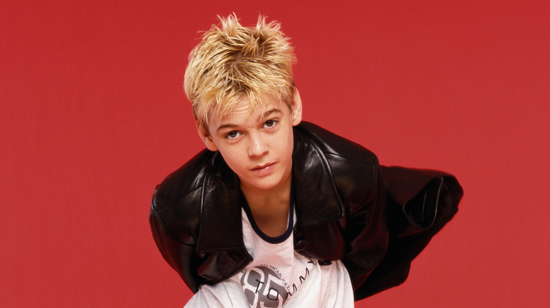 Un adolescent Aaron Carter devant un fond rouge