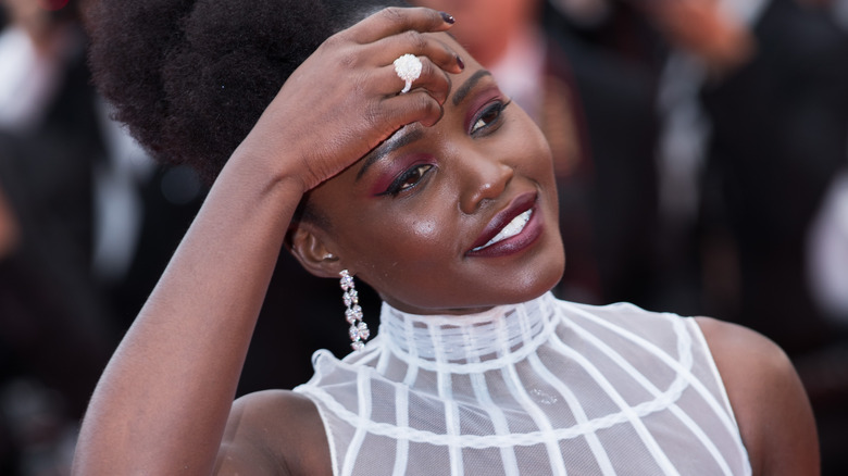 Lupita Nyong'o pose sa main sur sa tête