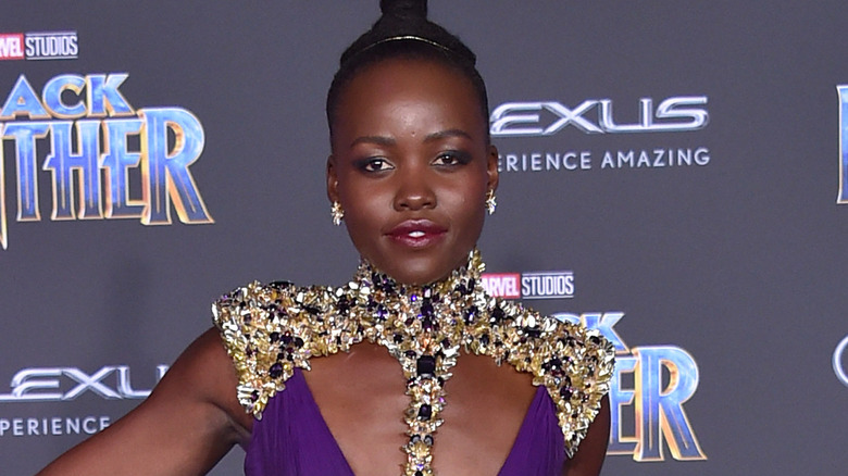 Lupita Nyong'o pose sur un tapis rouge