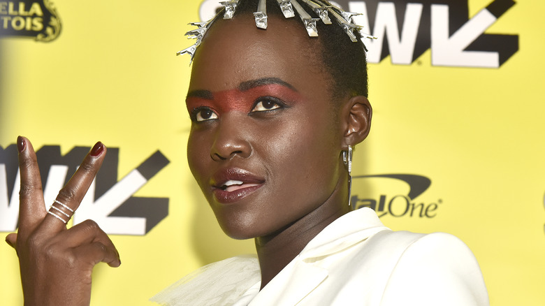 Lupita Nyong'o montre le signe de la paix