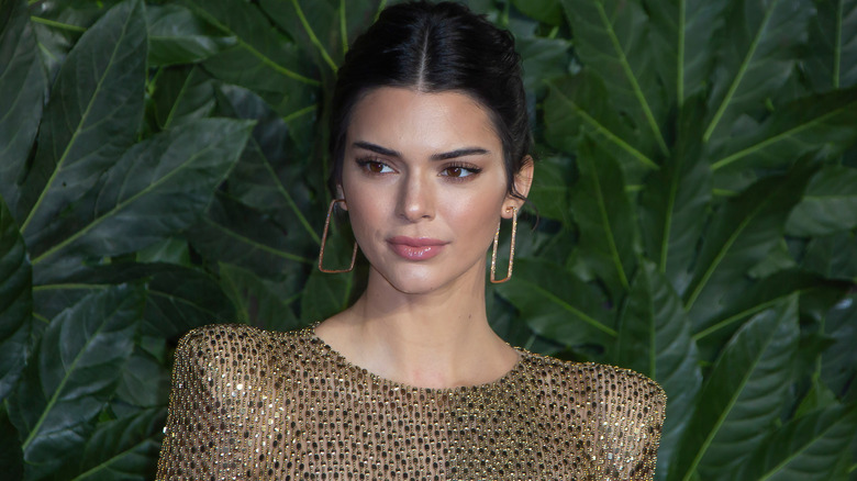 Kendall Jenner posant pour une photo avec des boucles d'oreilles en or