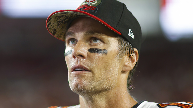 Tom Brady en casquette et portant des yeux noirs