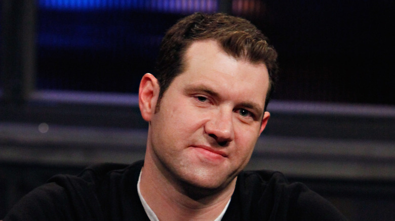 Billy EIchner souriant en pull