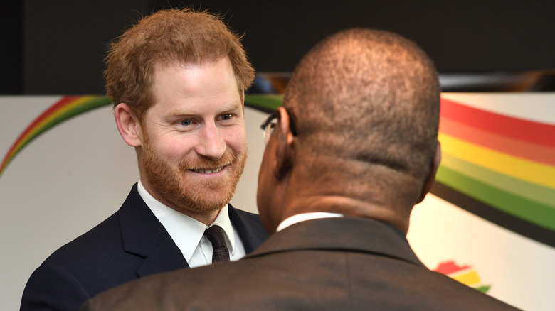 Prince Harry souriant parlant à l'homme