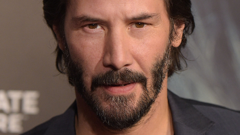 Keanu Reeves regarde profondément la caméra