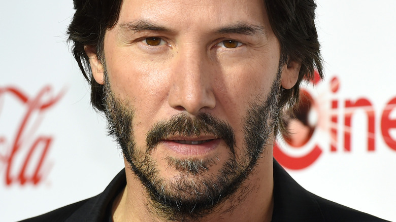 Keanu Reeves avec sa bouche légèrement ouverte