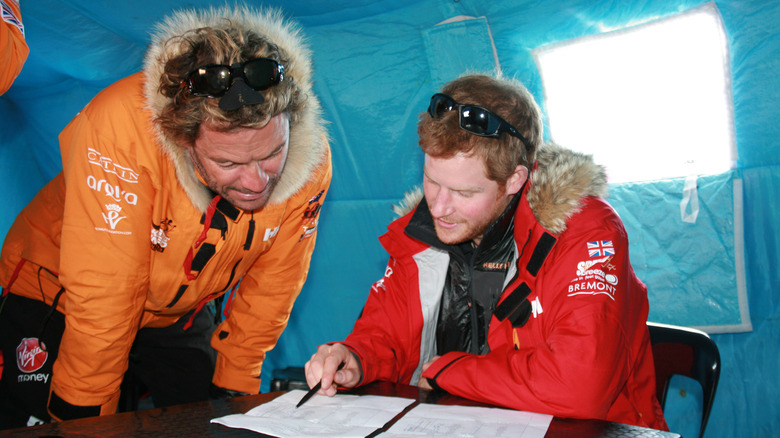 Dominic West et le prince Harry regardant un papier