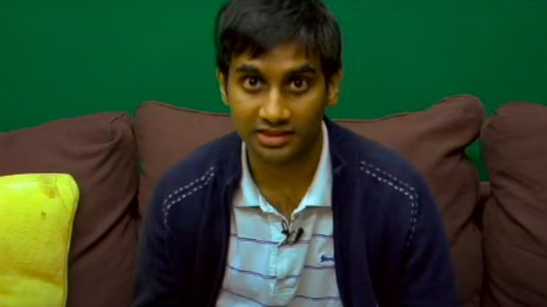 Aziz Ansari assis, regardant la caméra