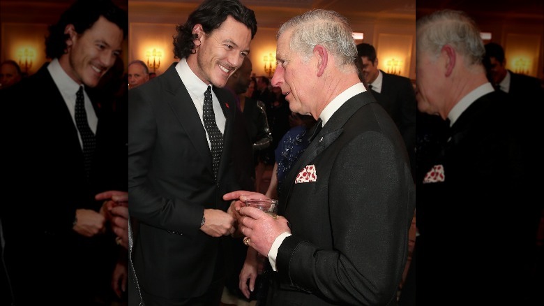 Luke Evans sourit en parlant avec Charles