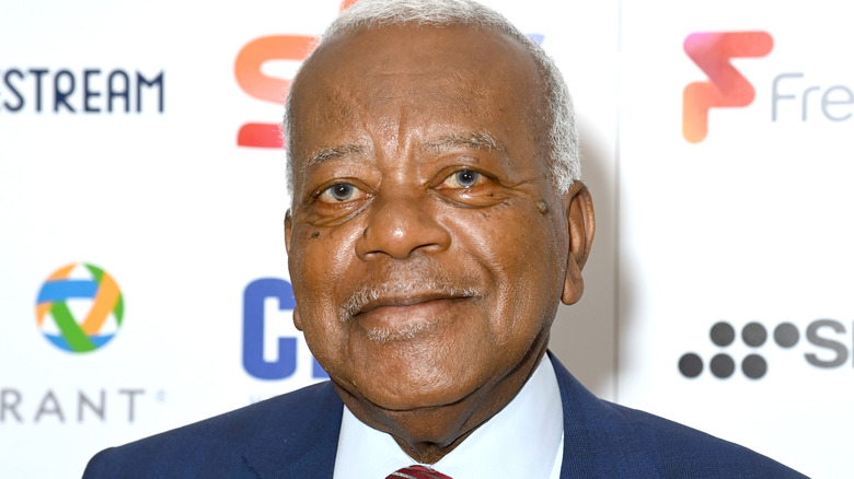 Sir Trevor McDonald sur un tapis rouge