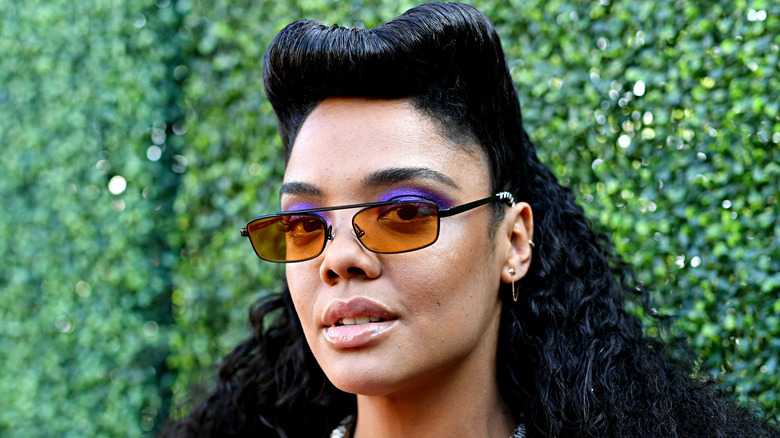 Tessa Thompson pose avec des lunettes de soleil sur le tapis rouge