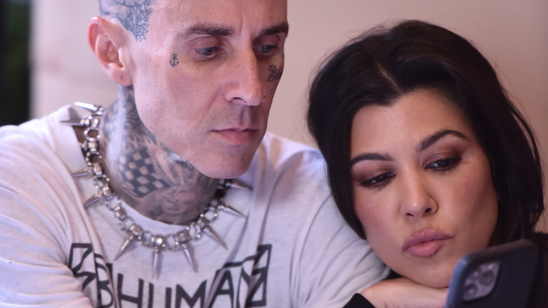 Travis Barker et Kourtney Kardashian regardent leur téléphone