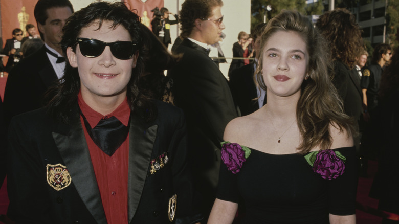 Corey Feldman et Drew Barrymore souriant ensemble