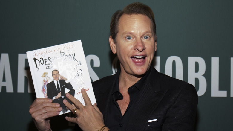 Carson Kressley posant avec un exemplaire de son livre