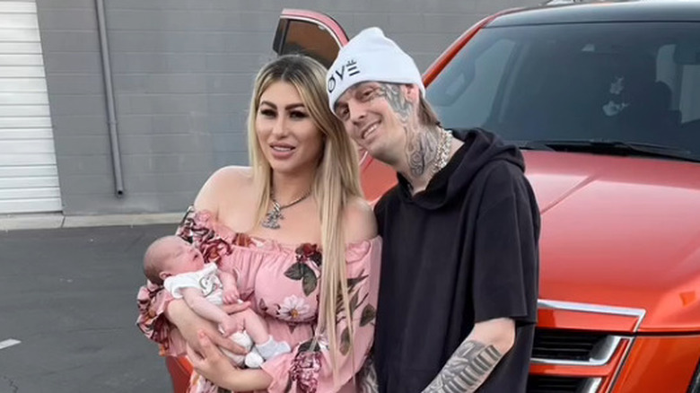 Melanie Martin et Aaron Carter posent à côté d'une voiture avec leur fils, Prince