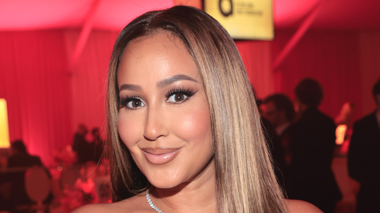 Adrienne Bailon souriante à l'événement