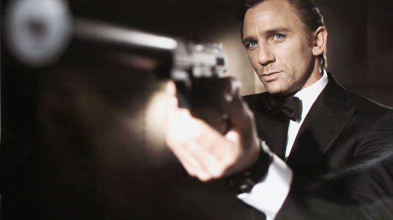 Daniel Craig dans le rôle de Bond tenant une arme