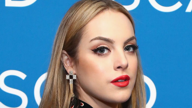 Liz Gillies aux cheveux blonds dans une pose sur l'épaule