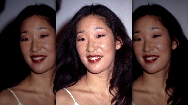 Jeune Sandra Oh posant en rouge à lèvres