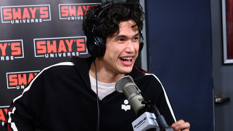 Charles Melton faisant une interview dans une émission de radio