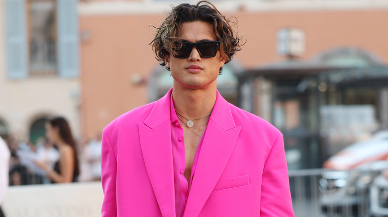 Charles Melton arrivant à un défilé de mode