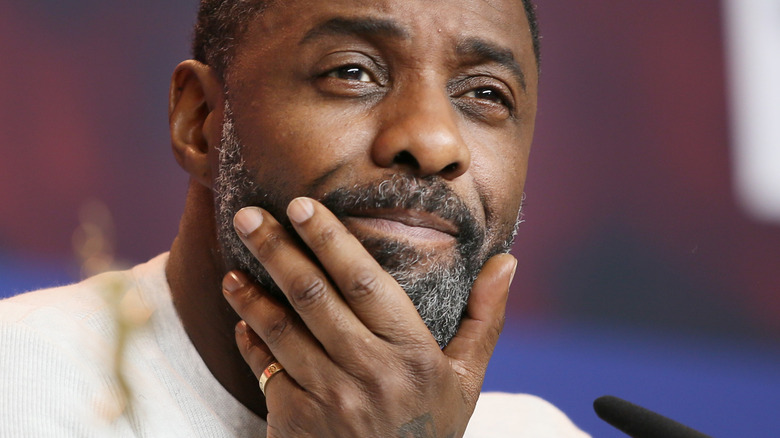 Idris Elba se tenant le menton 