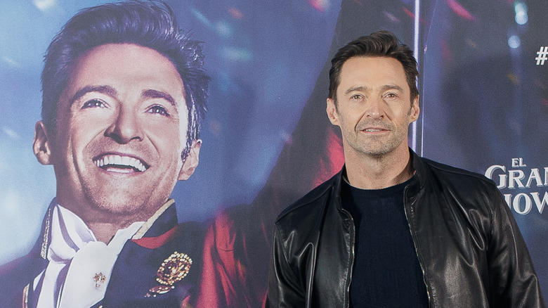 Hugh Jackman posant à côté d'une affiche de son visage